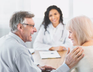 A mature couple gets good news about osteoarthritis treatment from a female osteoarthritis specialist in office.