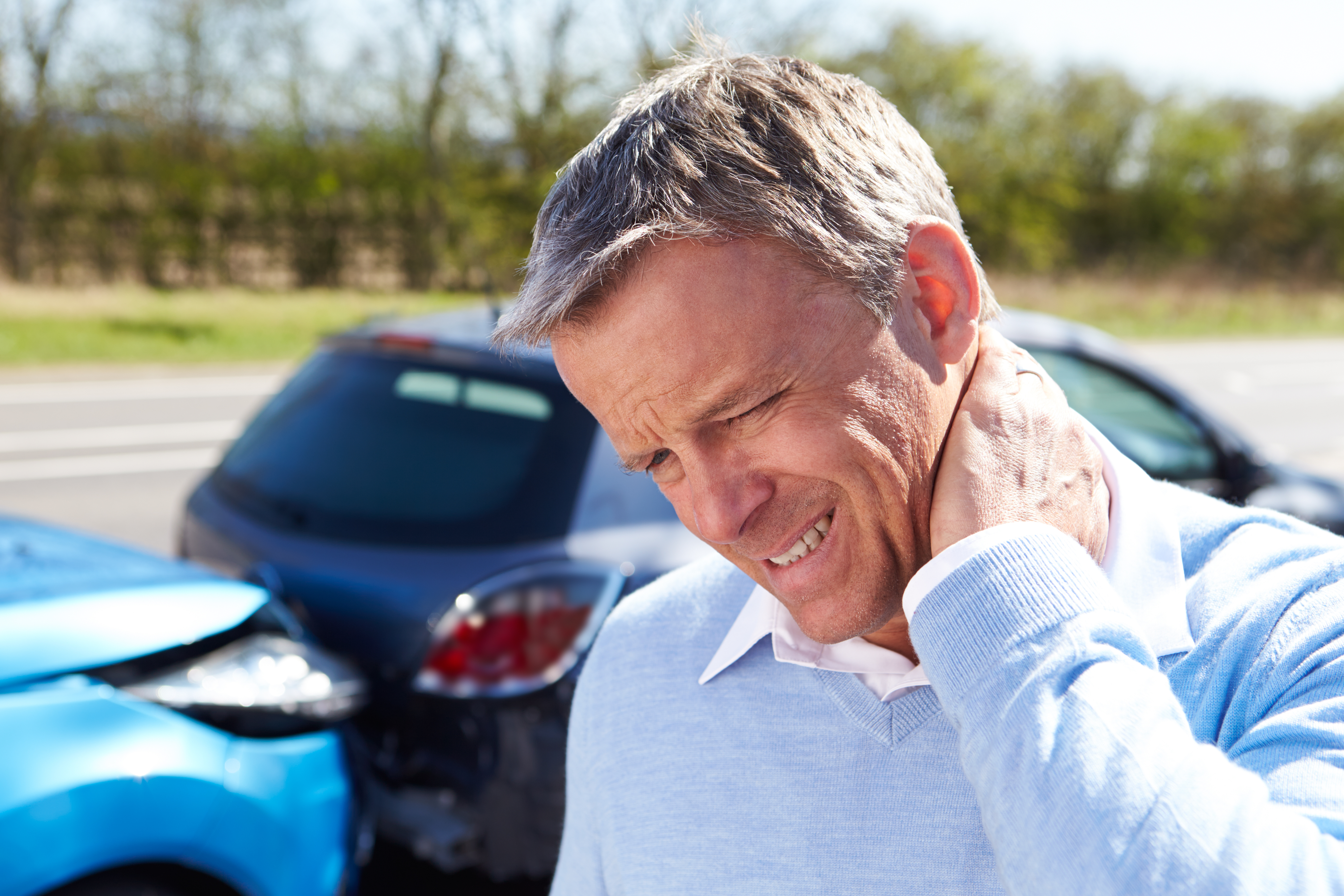  Man holds his neck in pain because of whiplash from a car accident. 
