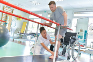 A physical therapist assists a patient with walking on a treadmill.