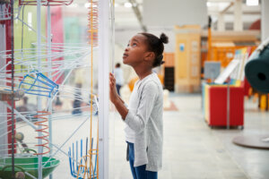 A young girl looks at a science exhibit at a children's museum.