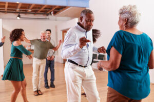 A group of seniors dances inside a studio.