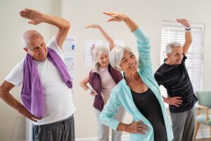 A group of seniors stretches in a fitness class.