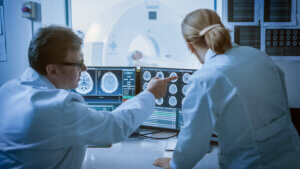 Two doctors discussing brain imaging from an MRI scan.