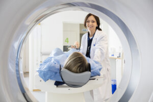 A doctor guiding her patient into an MRI machine.