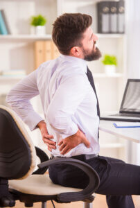 person sitting at desk affecting joint health daily routine