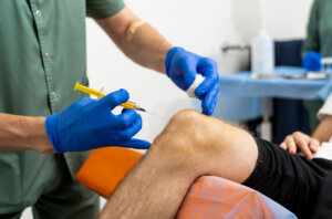 Sports medicine physician preparing PRP injection for post-traumatic arthritis