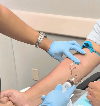 A clinical blood draw performed as part of the PRP therapy process before the blood is placed in a centrifuge for separation.