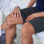 Orthopedic doctor examining a patient’s knee for pain and joint problems