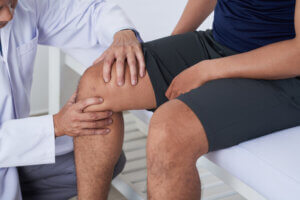 Orthopedic doctor examining a patient’s knee for pain and joint problems