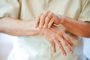 Person holding their wrist while experiencing hand and wrist joint pain